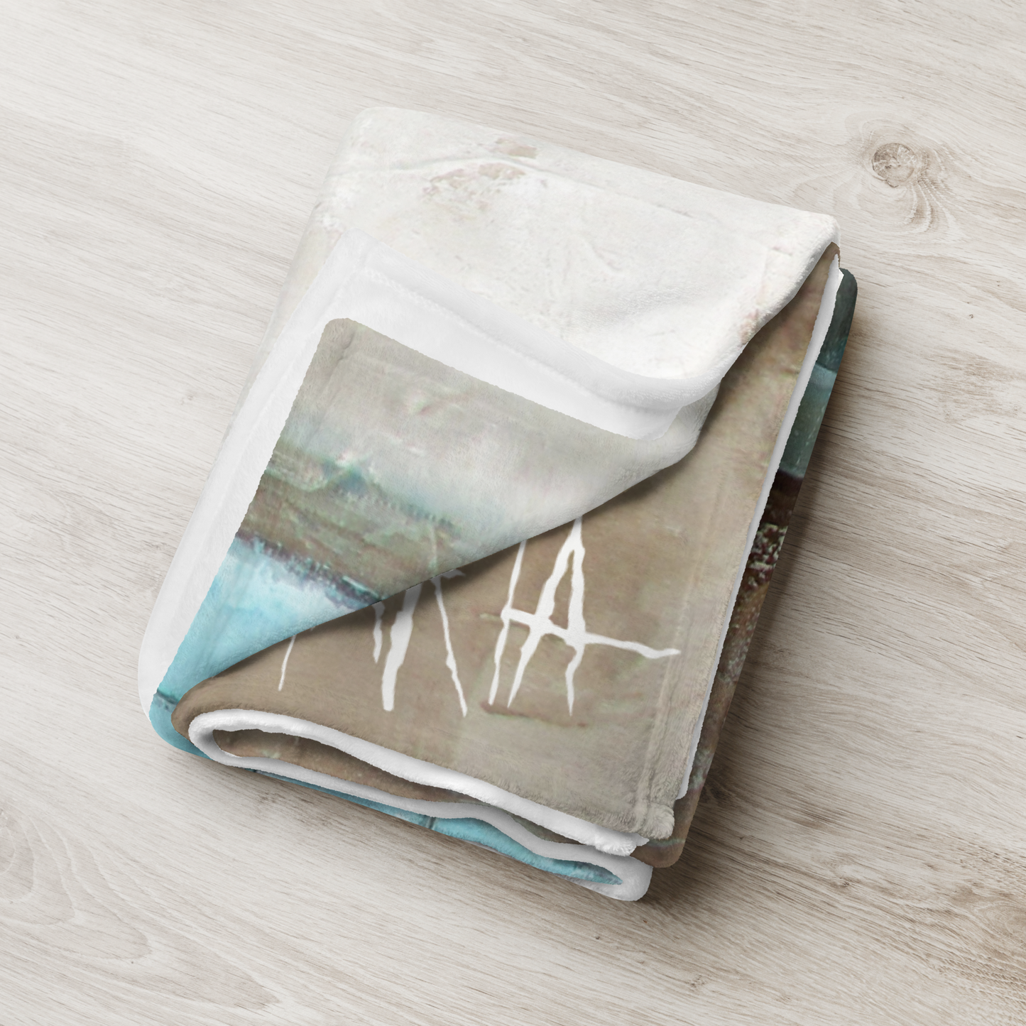 Folded blanket with artistic design on a wooden surface