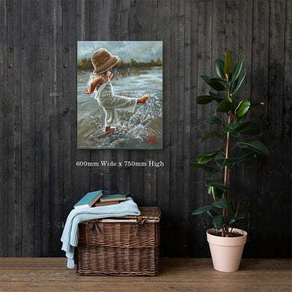 Lost in the Moment — a little girl in a straw hat splashing barefoot in the water by Maria Magdalena Oosthuizen, 600 x 750mm canvas print on a dark wood wall | canvas print wall art | House of Maria