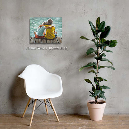 Wall art of two people sitting by a lake, white chair, and potted plant against a gray wall.