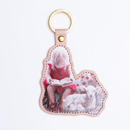 Once Upon a Lamb — leather-look key ring of a girl reading beside a lamb by Maria Magdalena Oosthuizen | faith key ring gift | House of Maria