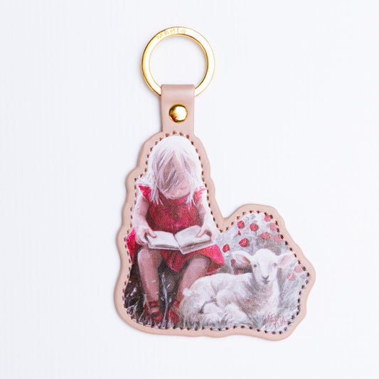 Once Upon a Lamb — leather-look key ring of a girl reading beside a lamb by Maria Magdalena Oosthuizen | faith key ring gift | House of Maria