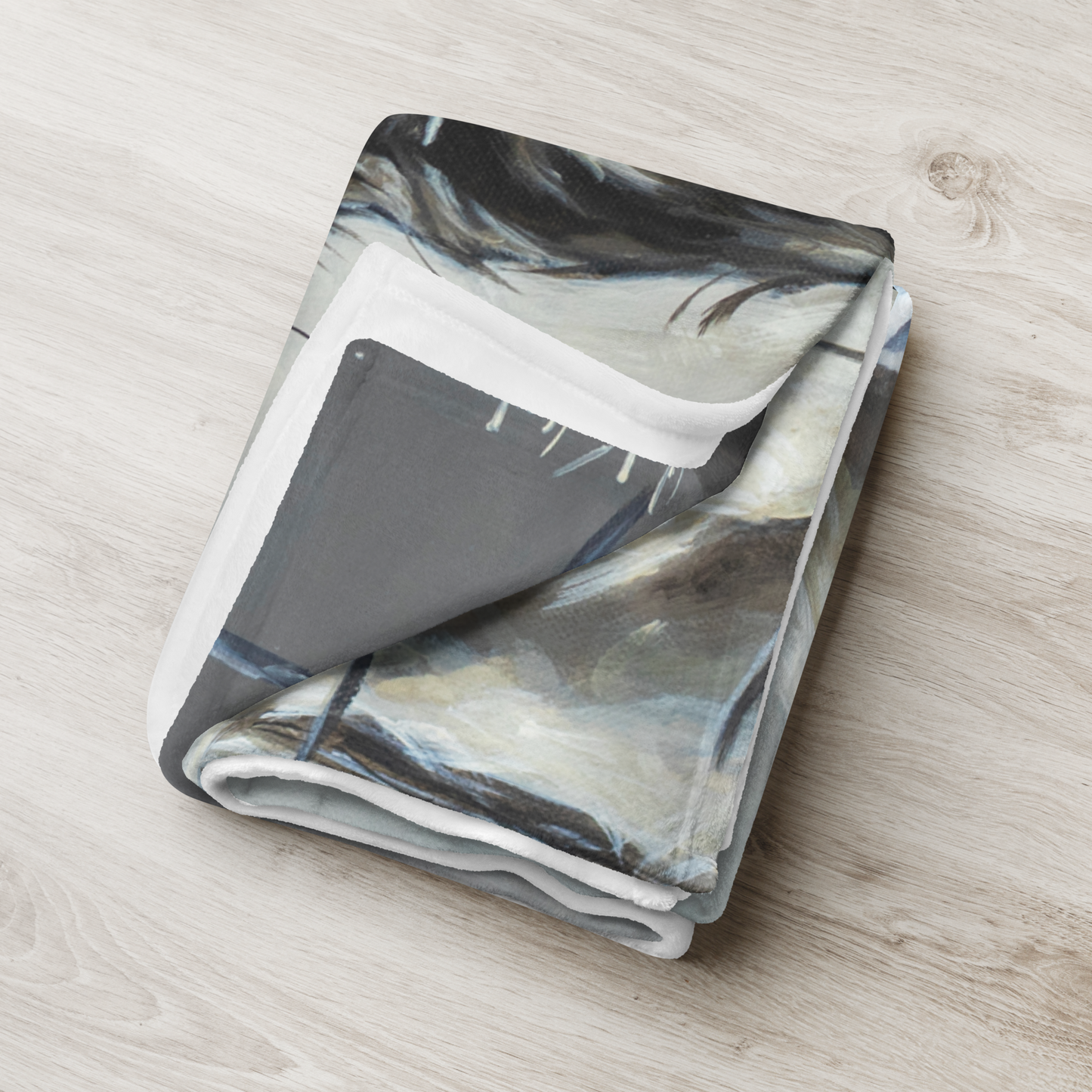 Folded blanket with abstract pattern on a wooden surface