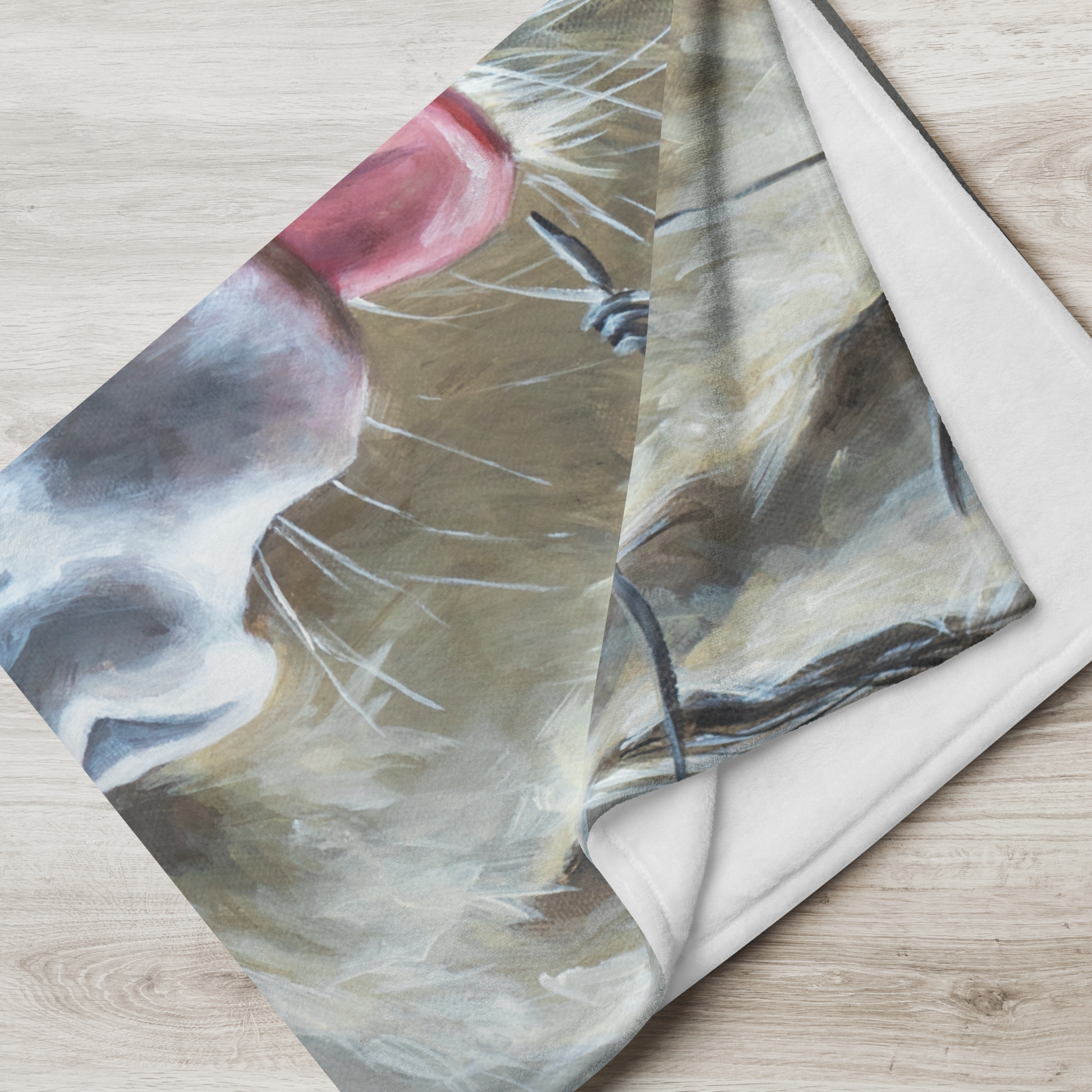 Folded fabric with a cat and bird design on a wooden surface