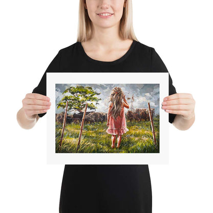 An artistic print featuring a girl in a pink dress with a cow in the background, set against a grassy field with a windmill in the distance.