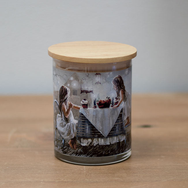 A vanilla scented wax candle with a cotton wick, placed in a clear whisky glass jar with a wooden lid, featuring a vanilla bean design.